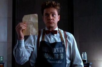 goofy looking man in 1950s mailroom apron holding up a piece of paper with a circle drawn on it