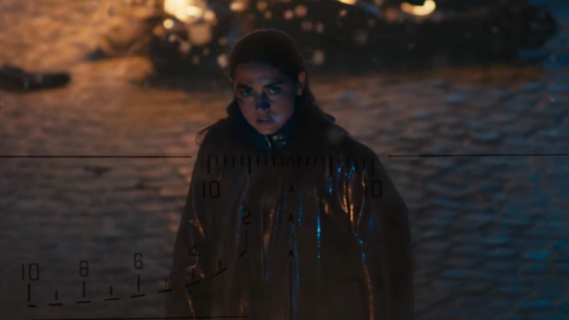 intense young woman looking up, seen through the crosshairs of a gun sight.